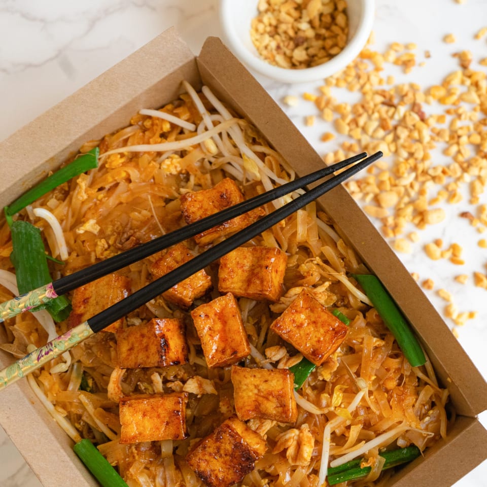 Cilantro Thai Express Pad Thai with tofu, bean sprouts, and green onions in a takeout box.