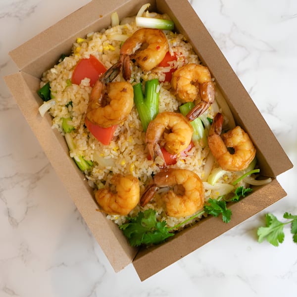 Thai shrimp fried rice with red peppers, green onions, and cilantro in a takeout container.